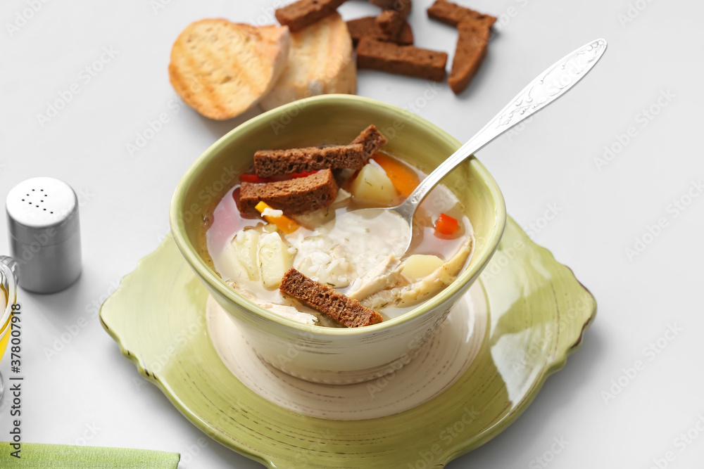 Bowl of tasty rice soup on white background