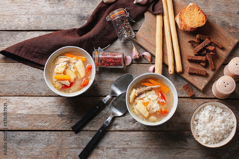 Bowls of tasty rice soup on table