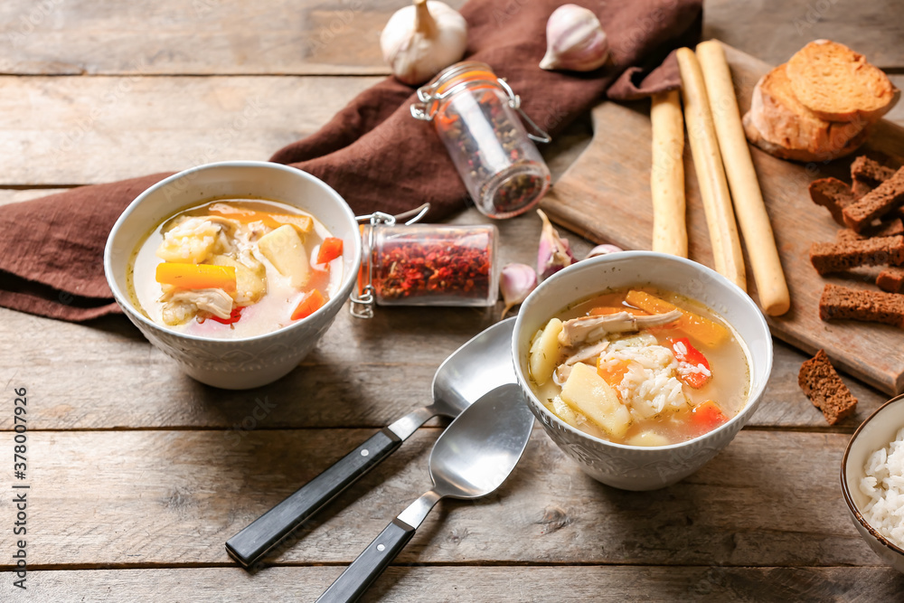 Bowls of tasty rice soup on table