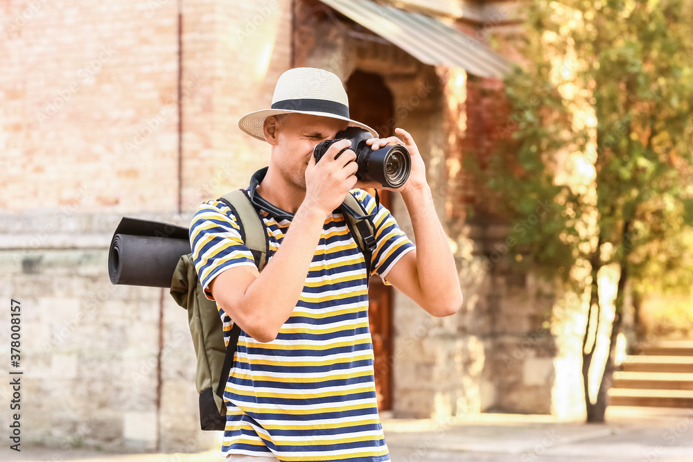 Male tourist taking photo on city street