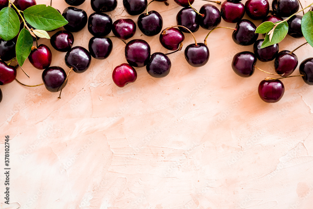 Layout of sweet cherries with leaves, top view, copy space