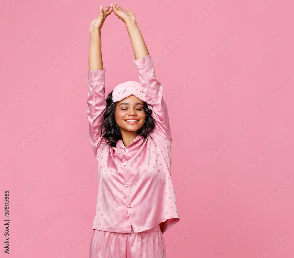 Happy ethnic woman stretching arms after sleep