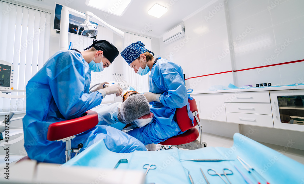 Patient in dentist chair. Providing surgery dentist operation in dental clinic. Stomatology concept.