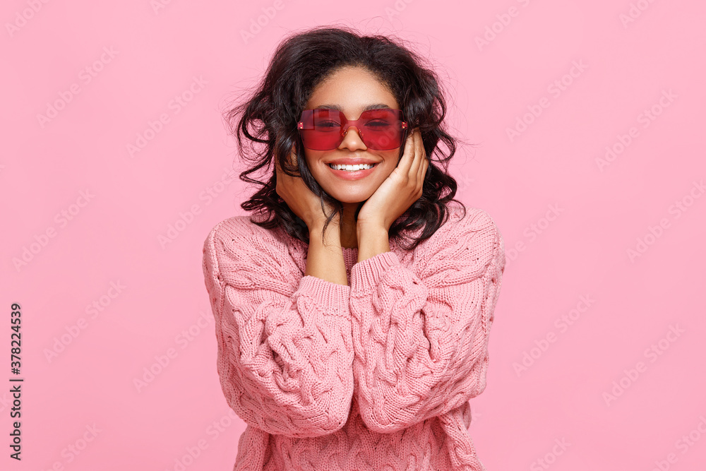 Happy ethnic woman in sunglasses laughing.