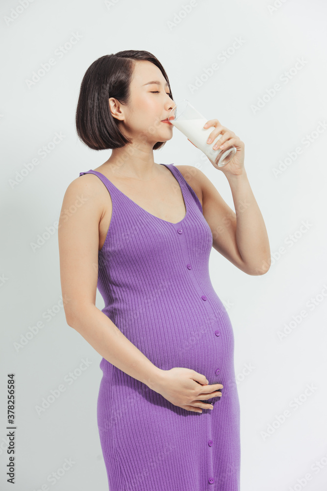 A woman drinking a glass of milk during her pregnancy