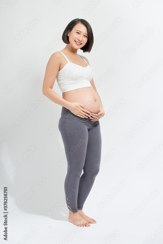 The young expecting mother holding baby in pregnant belly.