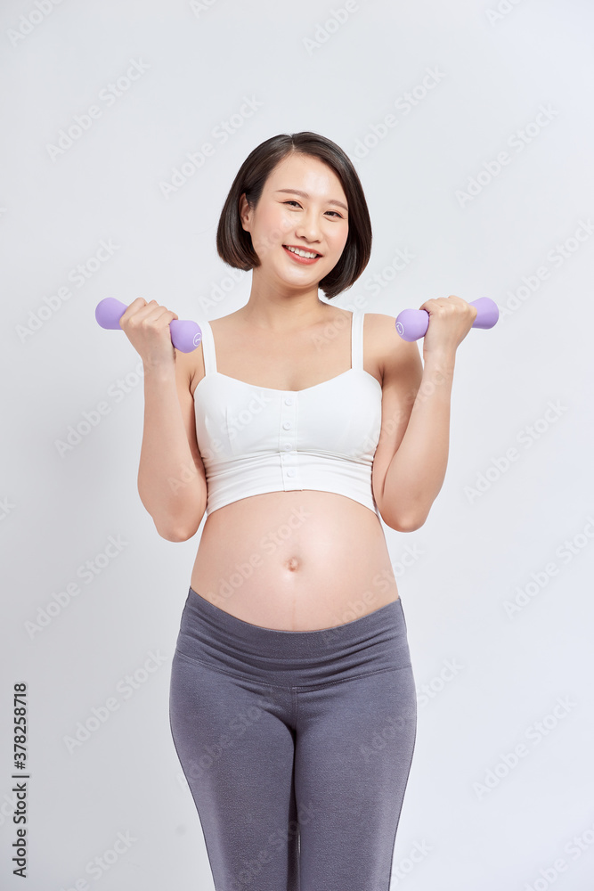 Pregnant woman is doing exercises at the gym