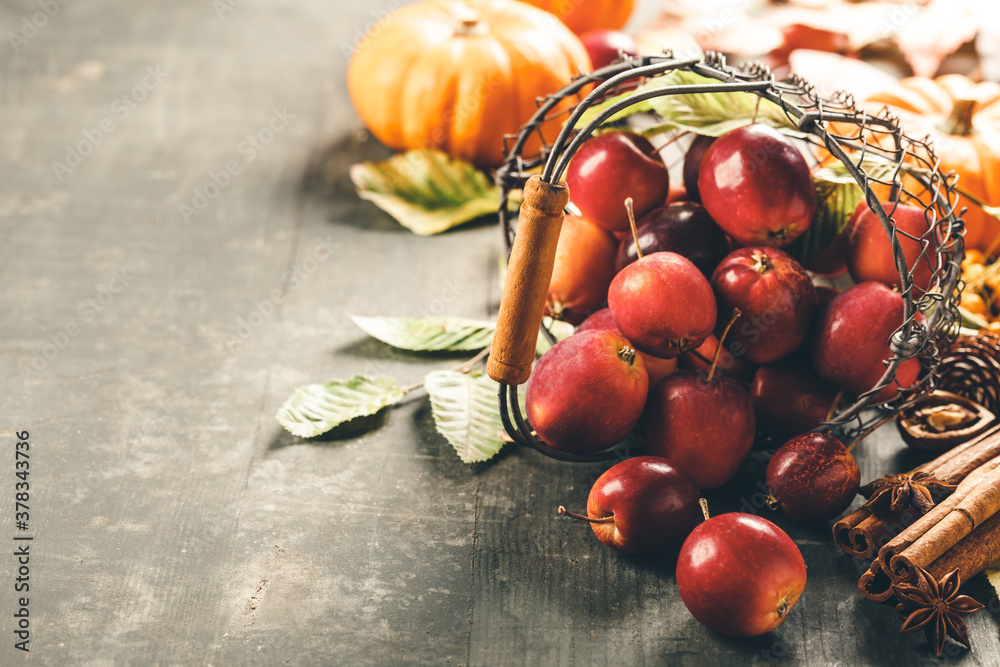 Apples in basket on old wooden background, space for text