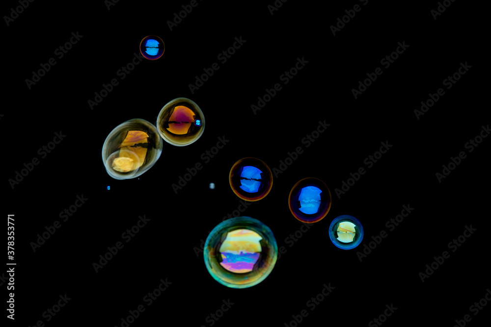 Flying soap bubbles isolated on black background.