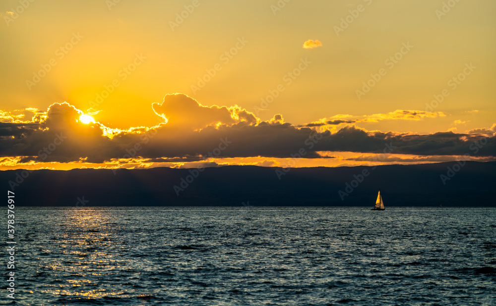 Lonely yacht on Lake Geneva at sunset in Switzerland