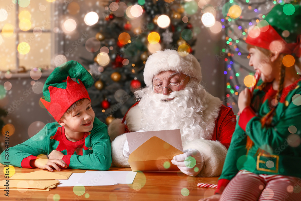 Elf kids with Santa Claus reading letter at home