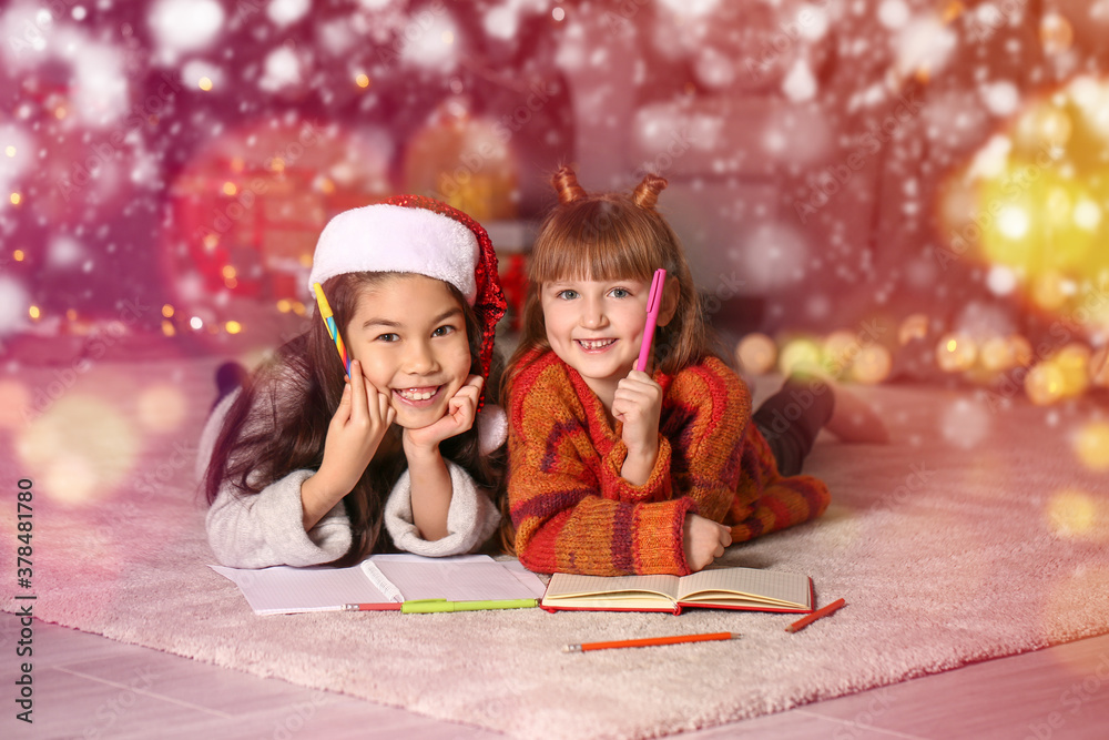 Cute little girls writing letter to Santa Claus on Christmas eve at home