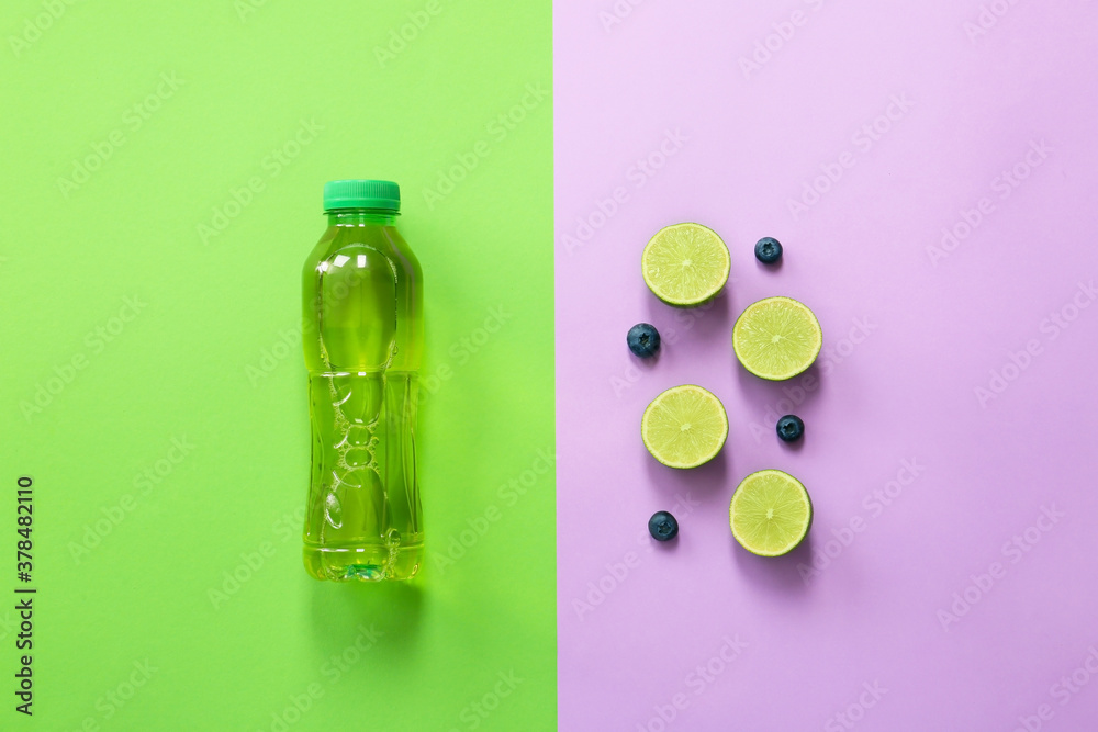 Bottle of fresh ice tea and ingredients on color background