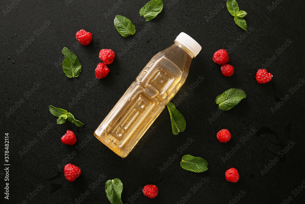 Bottle of fresh ice tea, mint and raspberry on dark background