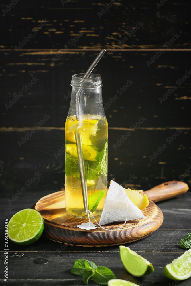 Bottle of fresh ice tea on dark background