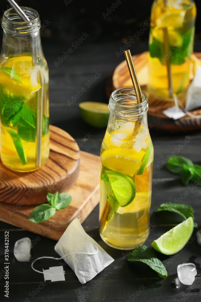 Bottles of fresh ice tea on dark background