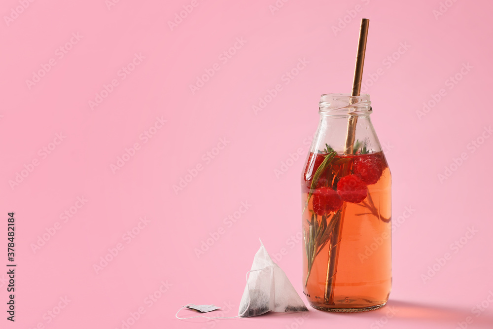 Bottle of fresh ice tea on color background