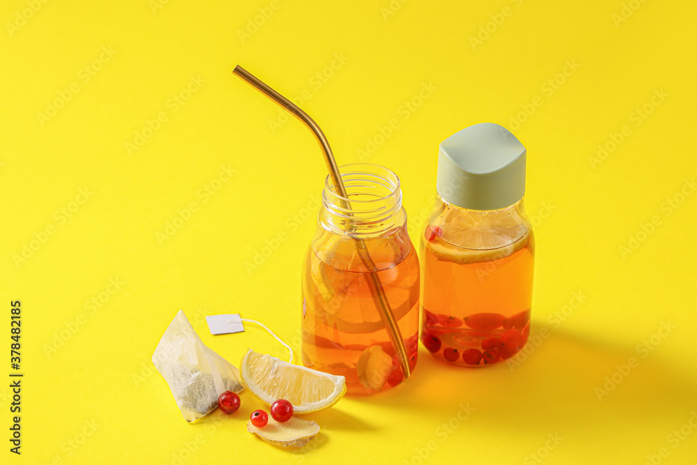 Bottles of fresh ice tea on color background