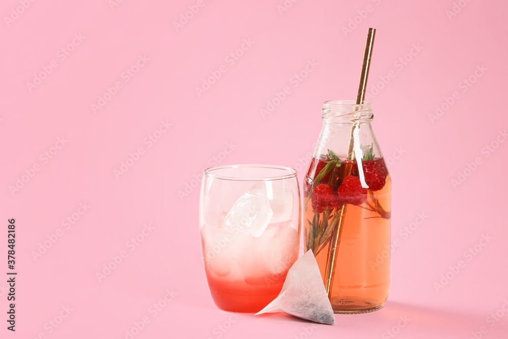 Bottle and glass of fresh ice tea on color background