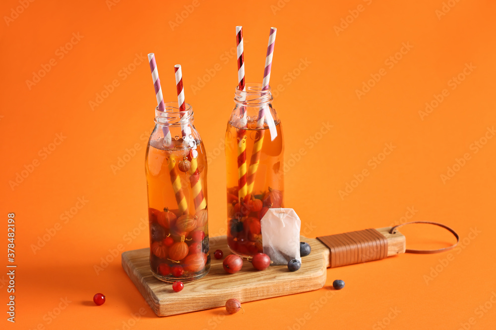 Bottles of fresh ice tea on color background