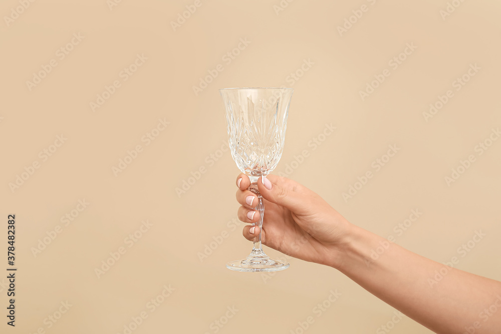 Hand with empty glass on color background