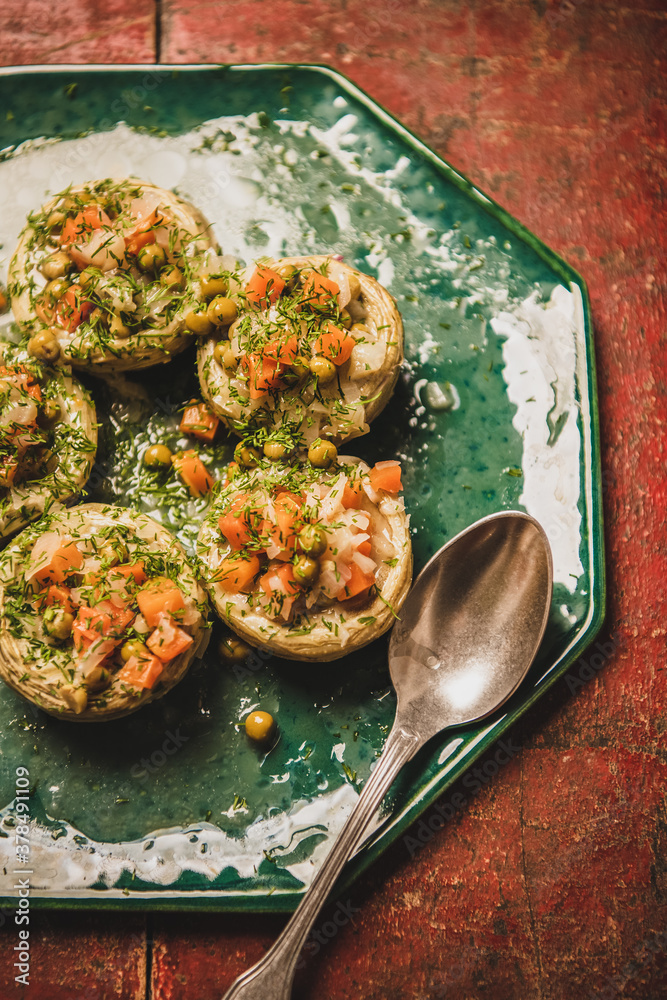 Turkish vegan artichoke salad. Flat-lay of artichoke bottoms filled with braised vegetables and gree