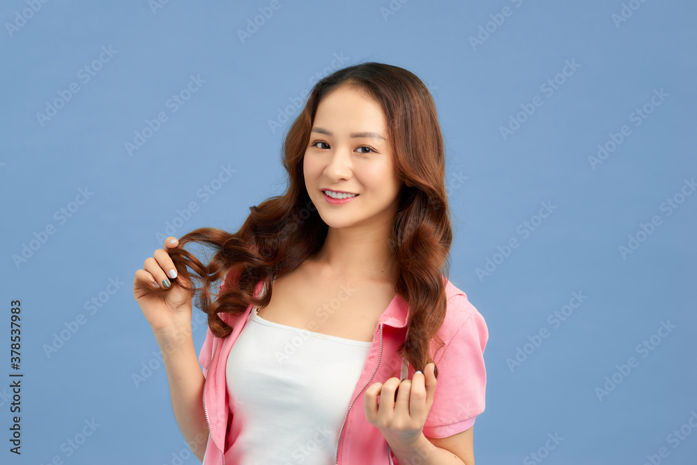 Trendy girl in casual summer white T-shirt and short white jeans with pink jacket isolated over blue