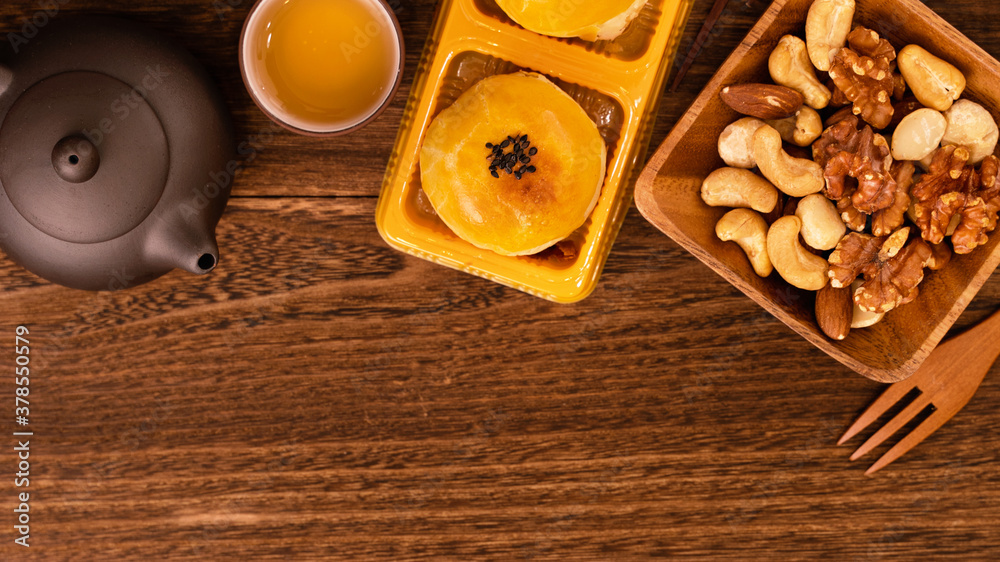 Moon cake for Mid-Autumn Festival, delicious beautiful fresh mooncake on a plate over dark wooden ba