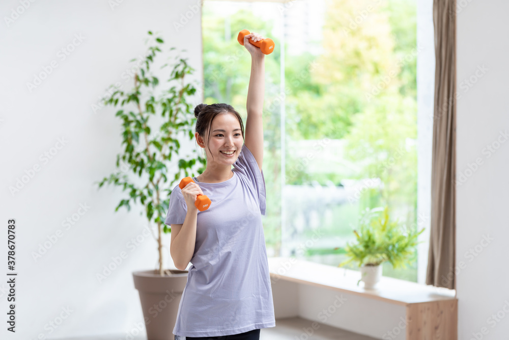 ダンベルを使って筋トレをする女性