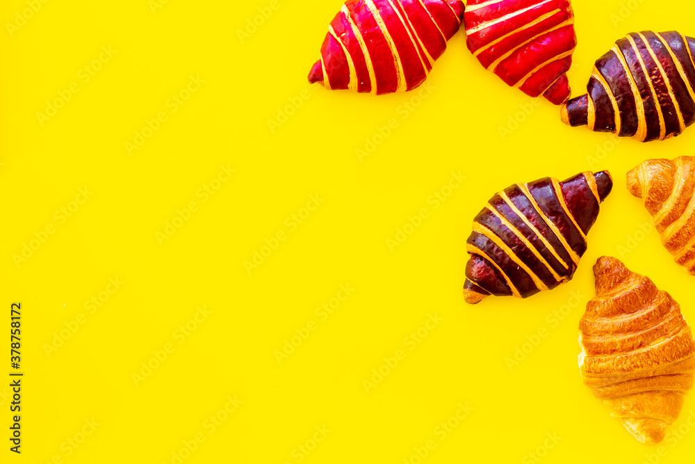 Set of croissants - chocolate, berry, classic - on yellow background top view