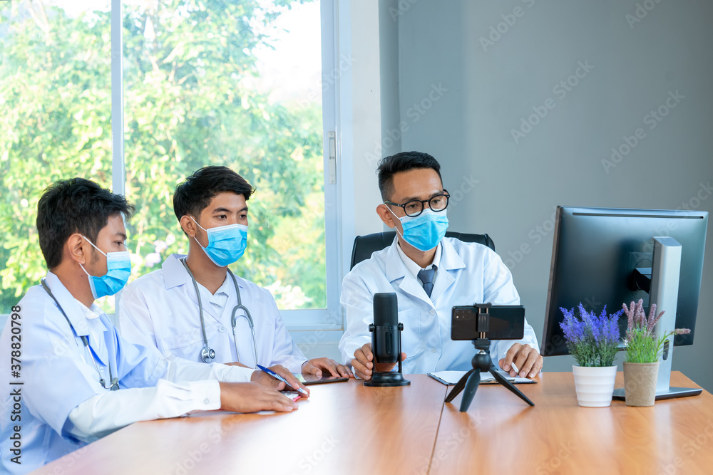 Group of doctor wearing protective surgical mask discuss work together and looking at online present