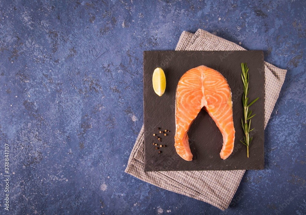 Slice of red salmon with lime, rosemary, with copy space for your text. The view from the top. Blue 