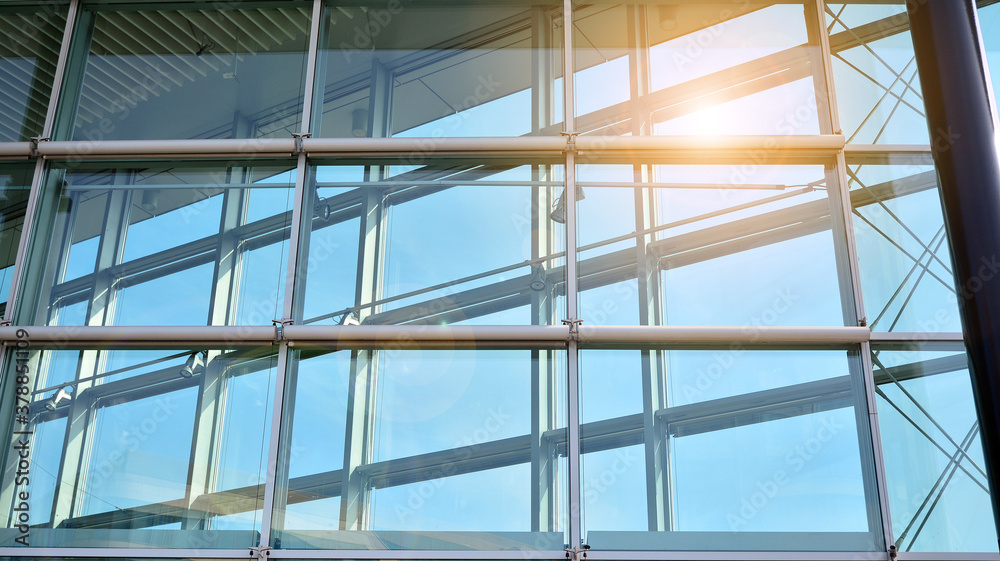 Office building, details of blue glass wall and sun reflections.