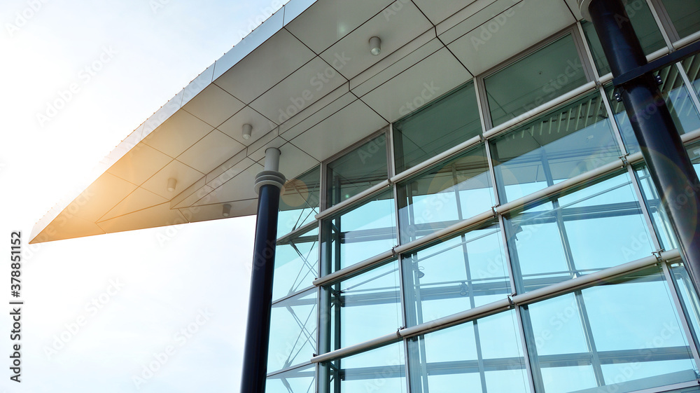 Office building, details of blue glass wall and sun reflections.