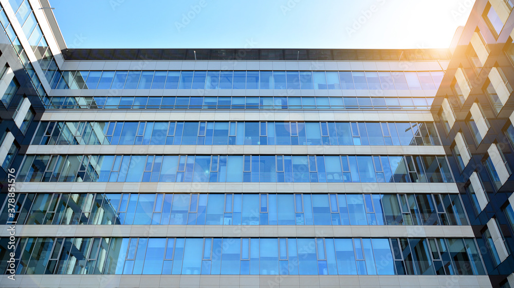 Office building, details of blue glass wall and sun reflections.