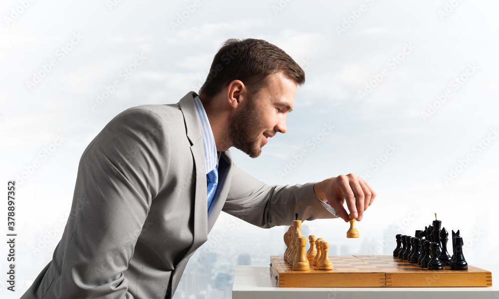 Concentrated businessman playing chess game