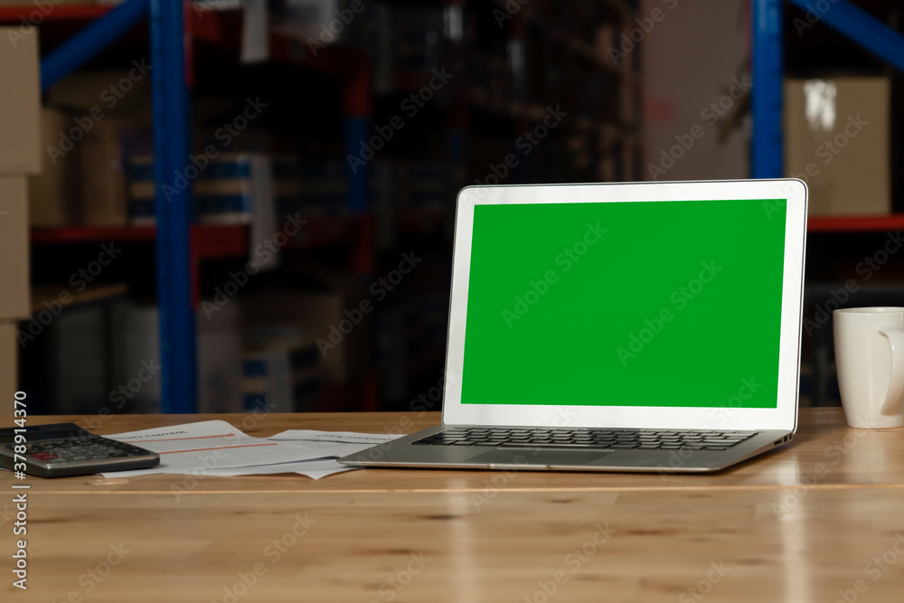 Computer with green screen display in warehouse storage room . Delivery and transportation software 