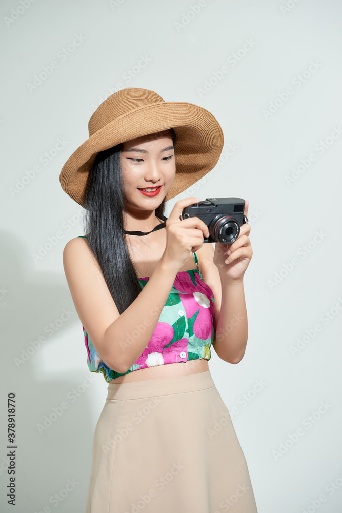 Beautiful happy cute asian woman in casual summer clothes takes photos holding retro photographic ca