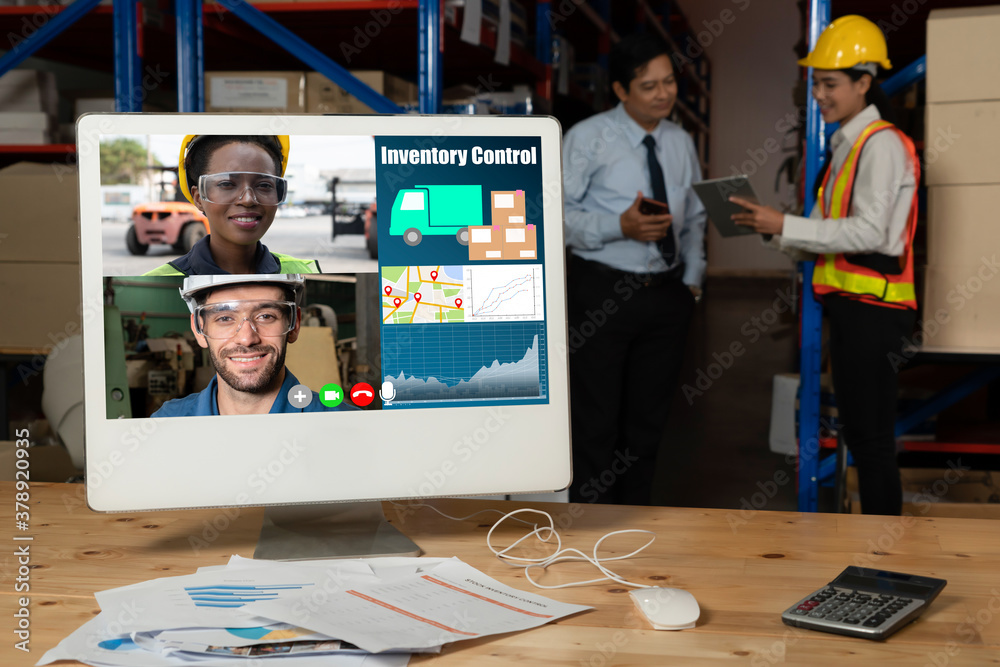 Warehouse staff talking on video call at computer screen in storage warehouse . Online software tech