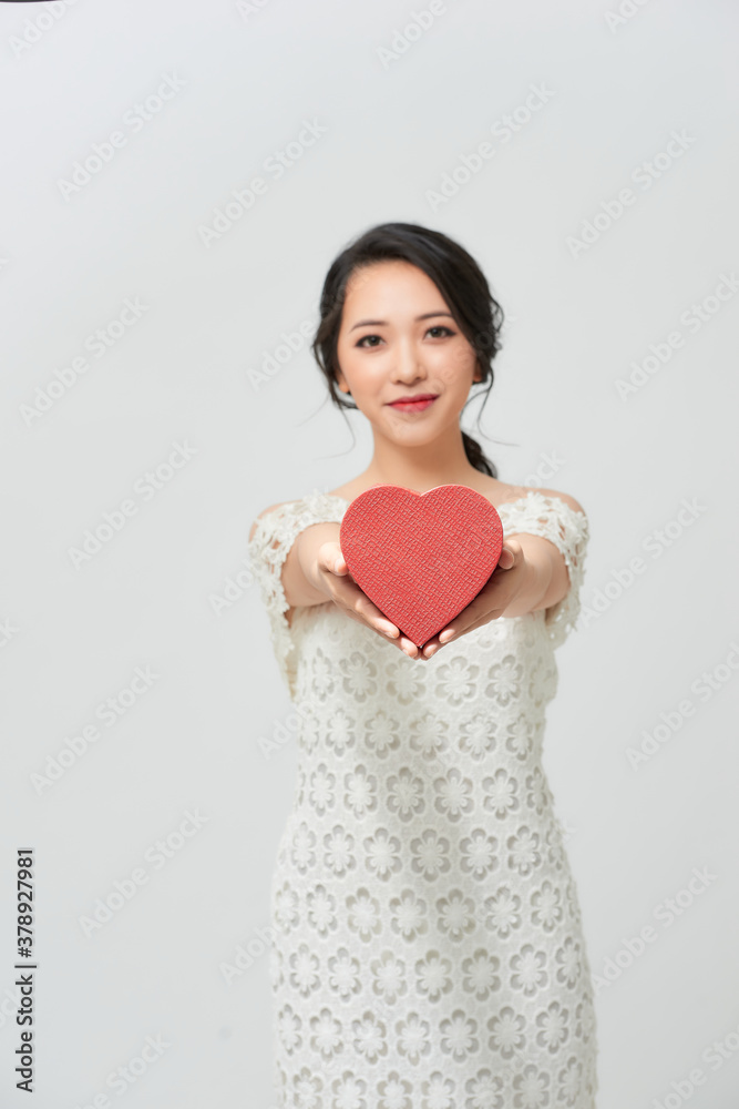 happiness, health, charity and love concept - smiling woman in white dress with red heart over white