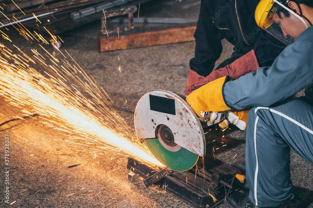 Professional mechanic man is cutting steel metal with rotating carbon blade cutter. Steel industry a