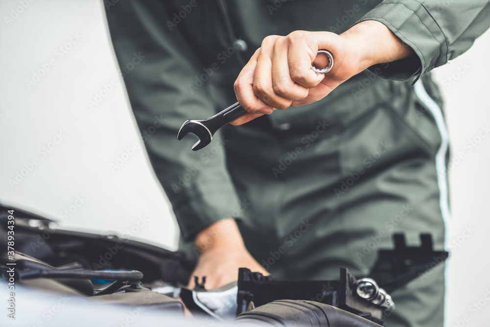 Professional mechanic hand providing car repair and maintenance service in auto garage. Car service 