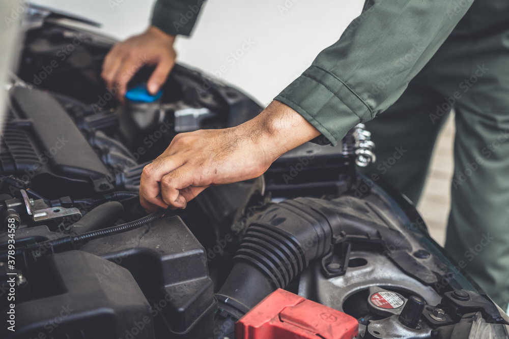 Professional mechanic hand providing car repair and maintenance service in auto garage. Car service 