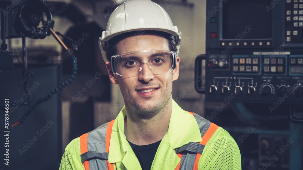 Young factory worker or engineer close up portrait in factory . Industry and engineering concept .