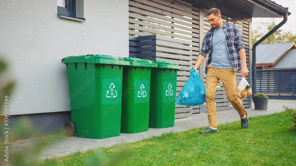 Caucasian Man is Walking Outside His House in Order to Take Out Two Plastic Bags of Trash. One Garba