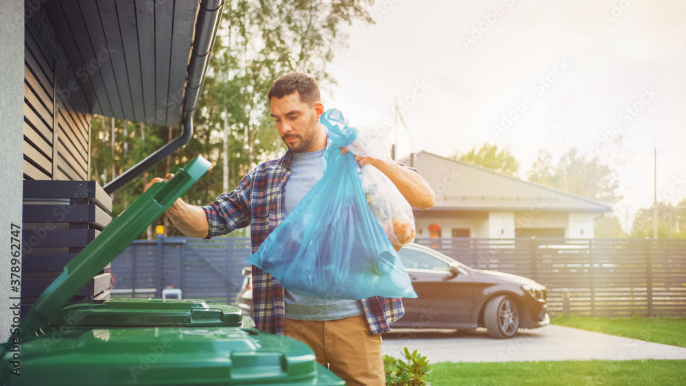 Caucasian Man is Throwing Away Two Plastic Bags of Trash next to His House. One Garbage Bag is Sorte