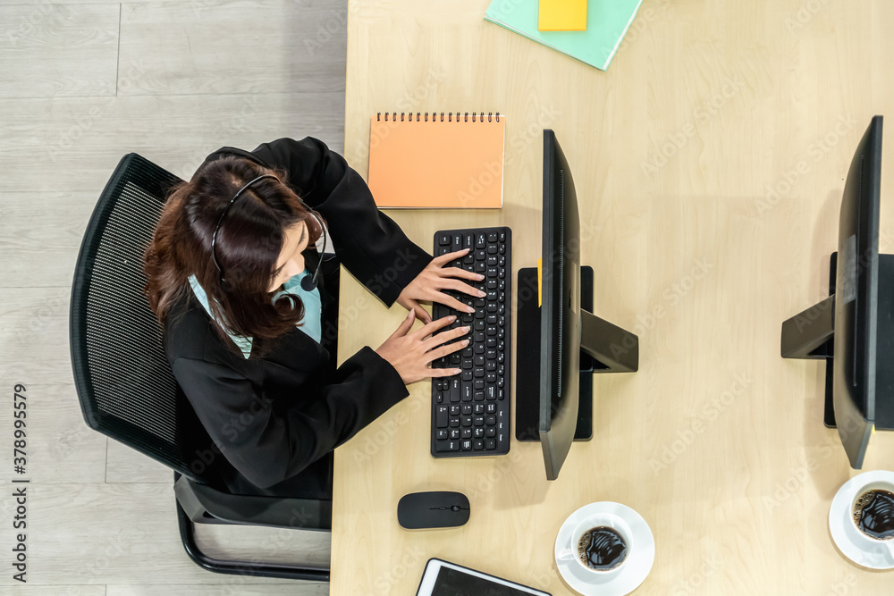 Business people wearing headset from top view in office working with computer to support remote cust