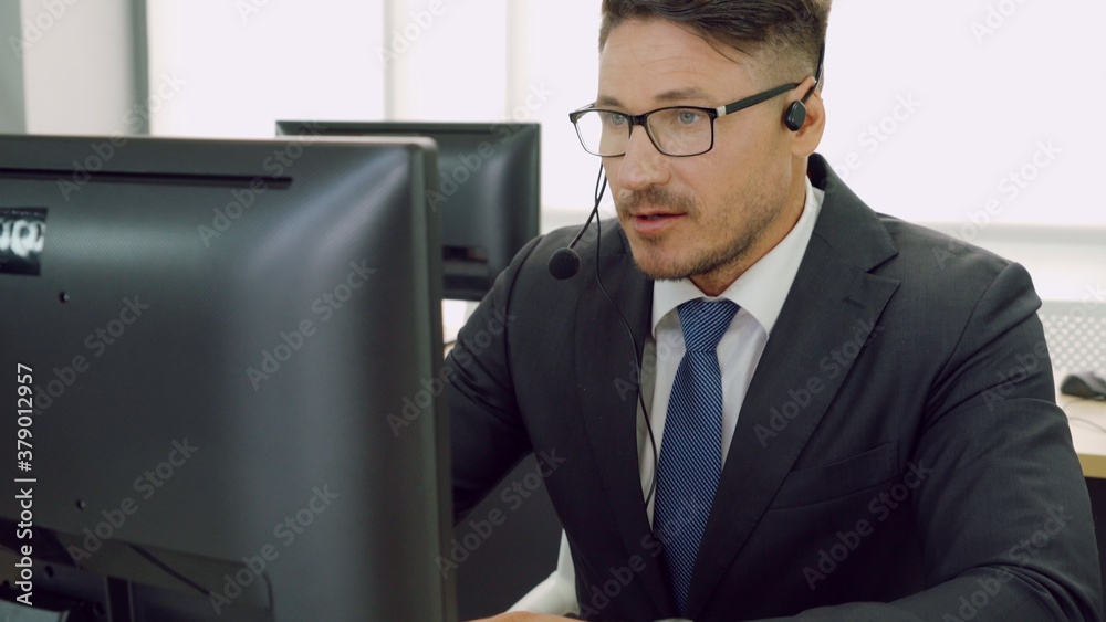 Business people wearing headset working in office to support remote customer or colleague. Call cent