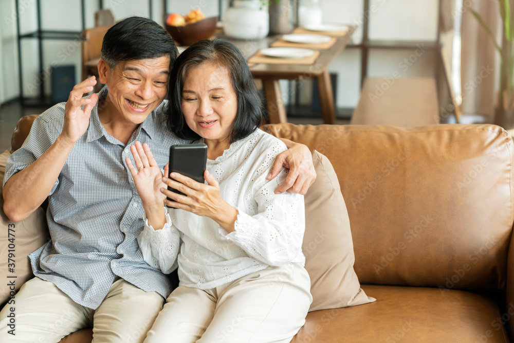 Happy senior old asian lover couple holding smartphone looking at cellphone screen laughing casual r