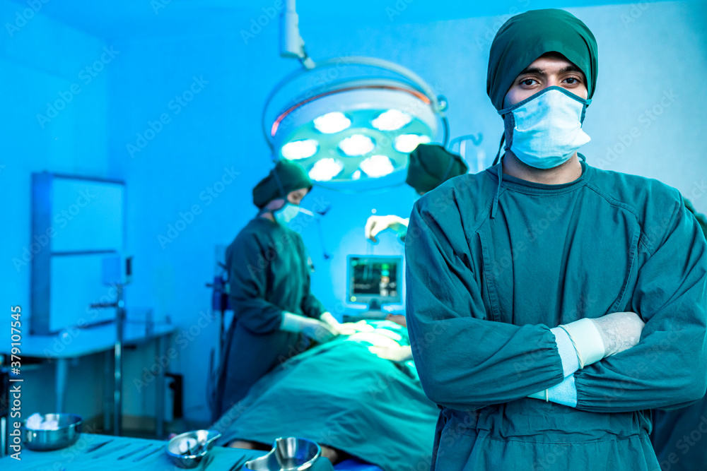 Portrait of professional confident caucasian male doctor surgeon standing in operating room, ready t